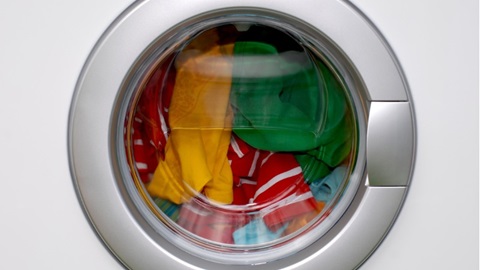 wasmachine van dichtbij met gekleurde was erin
